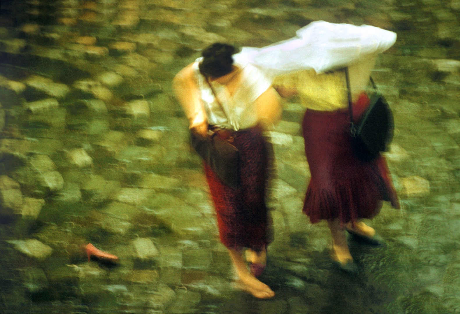 Fotografia *Pantoful roșu* - Doua femei mergând grăbit pe timp de ploaie.